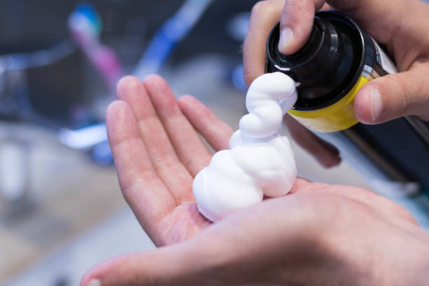 Close up of man pouring shaving foam on his hand.