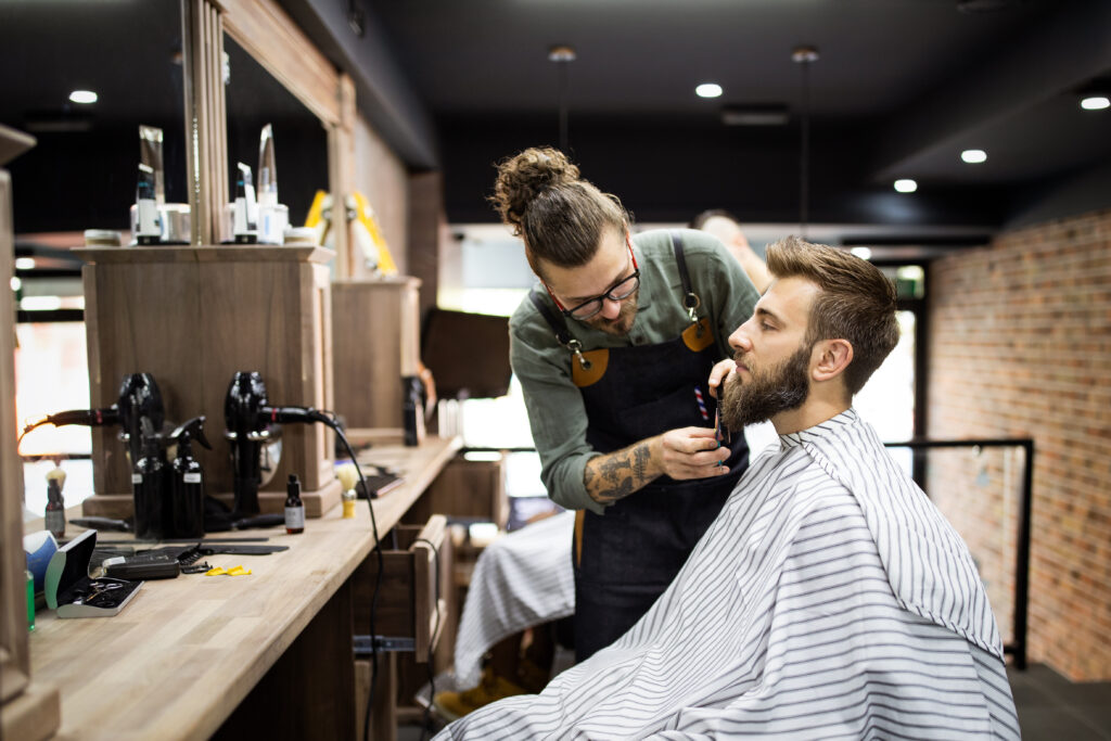 Client man during beard shaving in barber shop