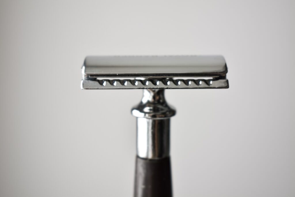 A set of shaving accessories. The machine is in the hands of a man.
