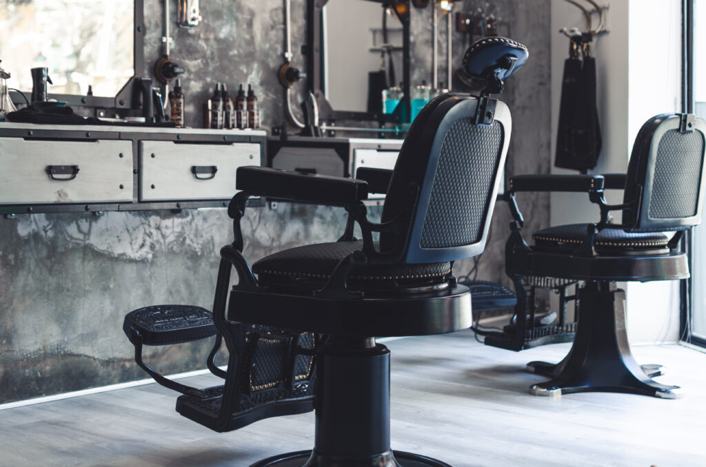 Two black leather and iron barber chairs in an old style barber shop